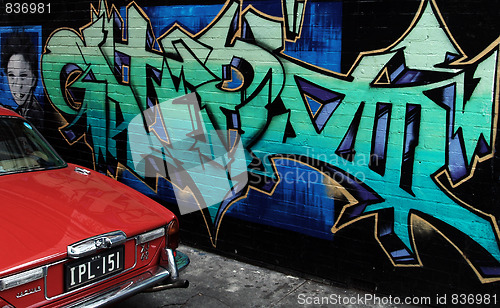 Image of Grafitti and an old jaguar in an ally