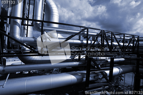 Image of Pipes, bolts, valves against blue sky in blue tones