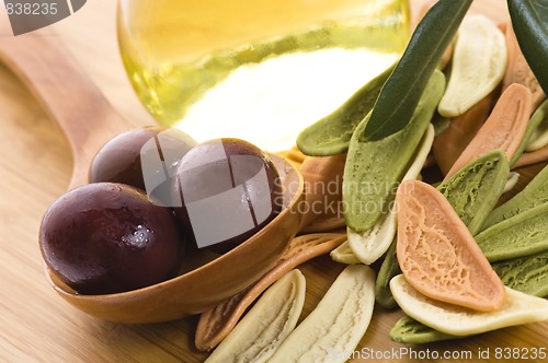 Image of pasta, black olives, oil with fresh branch. food ingredients 