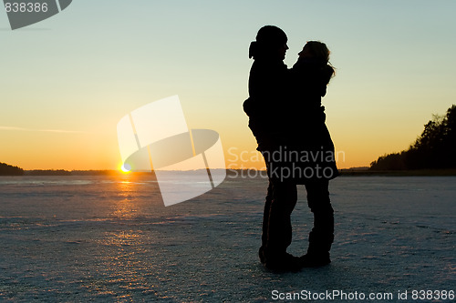 Image of Silhouette of a couple hugging on ice