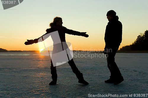 Image of Silhouette of couple having fun on ice