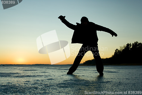 Image of Silhouette of a man glidin on ice