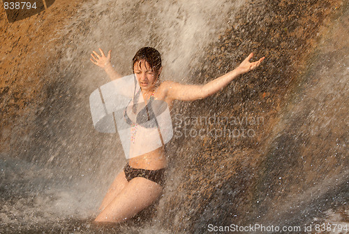 Image of Beautiful girl under waterfall