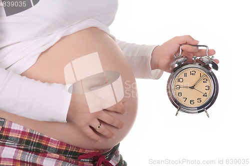 Image of pregnant woman with alarm clock waiting 