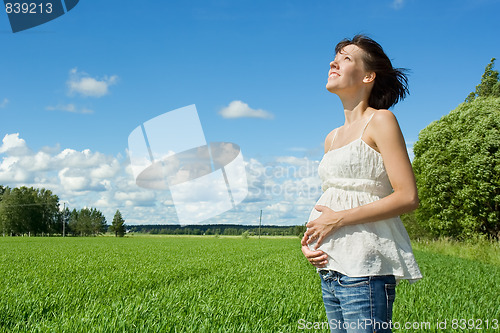 Image of Pregnant woman smiling on field