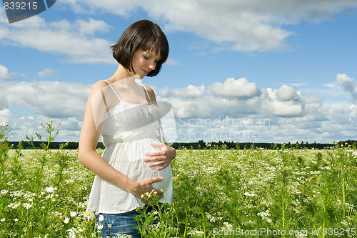 Image of Pregnant woman smiling on a field