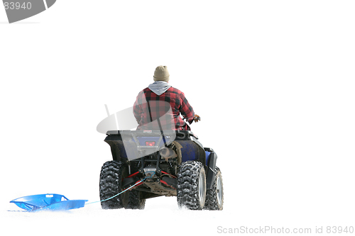Image of ATV on snow pulling sled