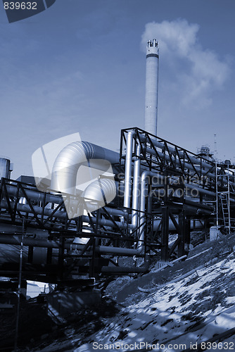 Image of industrial pipelines on pipe-bridge against blue sky