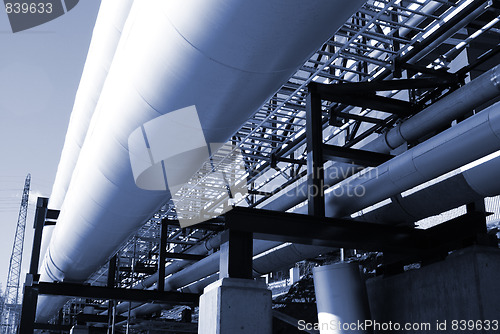 Image of industrial pipelines on pipe-bridge against blue sky