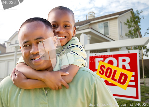 Image of Father and Son In Front of Real Estate Sign and Home