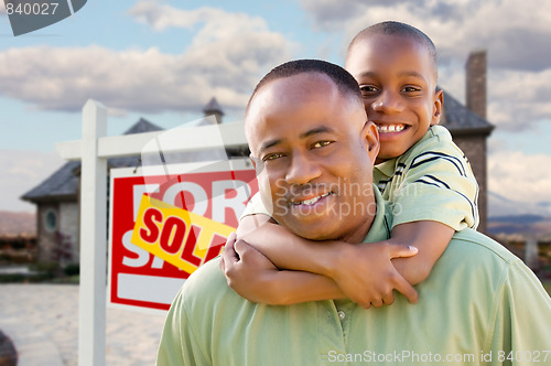 Image of Father and Son In Front of Real Estate Sign and Home