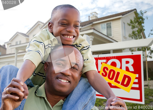 Image of Father and Son In Front of Real Estate Sign and Home