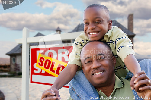 Image of Father and Son In Front of Real Estate Sign and Home