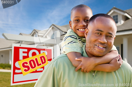 Image of Father with Son In Front of Real Estate Sign and Home