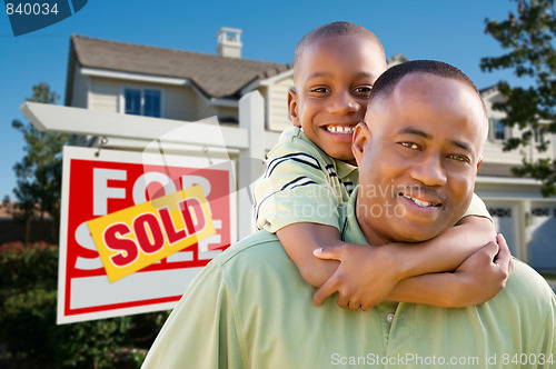 Image of Father and Son In Front of Real Estate Sign and Home