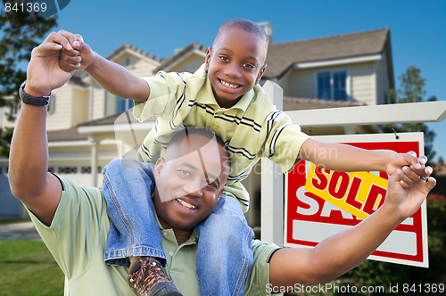 Image of Father and Son In Front of Real Estate Sign and Home