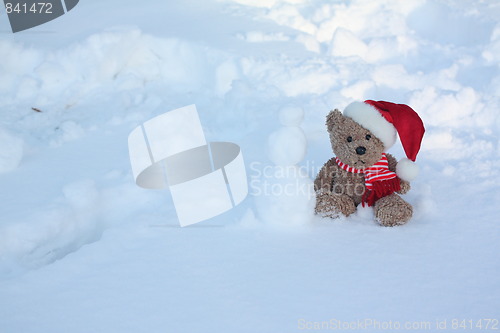 Image of Bear making a snowman.