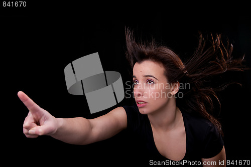 Image of beautiful young woman with her hair in the wind, finger in the air, looking up