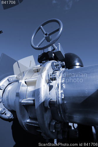 Image of  Pipes, bolts, valves against blue sky in blue tones