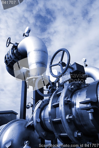 Image of  Pipes, bolts, valves against blue sky in blue tones