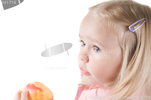 Image of Little girl eating peach in studio