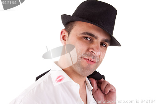 Image of seductive man with his hat, the shirt with lipstick mark