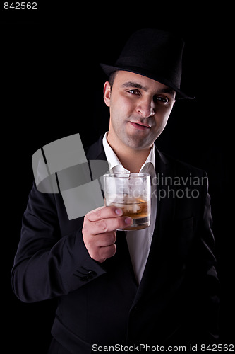 Image of  young man with a black hat and a glass of whiskey in his hand