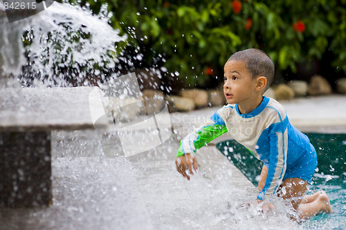 Image of cute boy playing with water