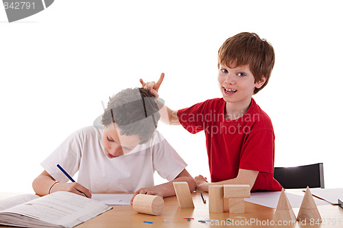 Image of two students in the classroom, making ugly gestures