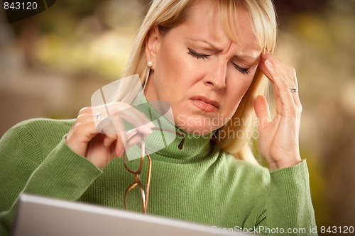 Image of Grimacing Woman Suffering a Headache