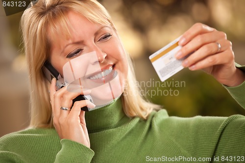 Image of Cheerful Woman Using Her Phone with Credit Card