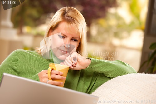 Image of Beautiful Woman Enjoys Her Warm Drink and Laptop