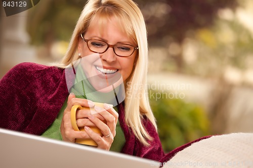 Image of Beautiful Woman Enjoys Her Warm Drink and Laptop