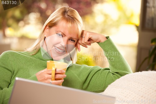 Image of Beautiful Woman Enjoys Her Warm Drink and Laptop