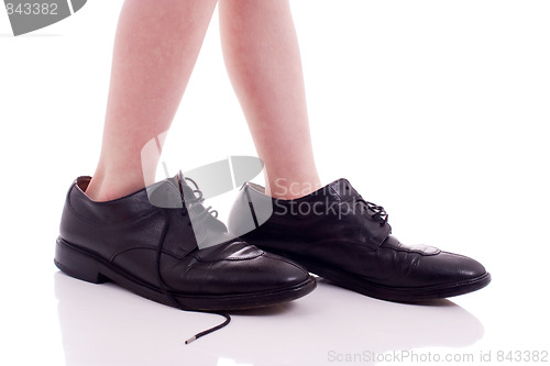 Image of Child wearing adult shoes