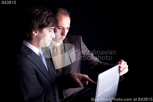 Image of Two businessmen working together on a laptop