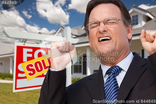 Image of Excited Man in Front of Sold Real Estate Sign and House