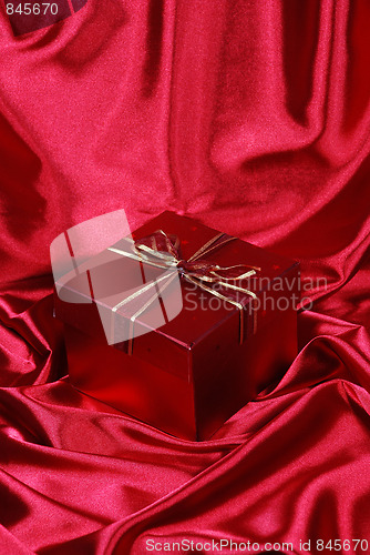 Image of gift box on red satin background