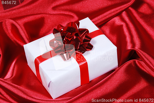 Image of gift box on red satin background