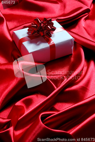 Image of gift box on red satin background