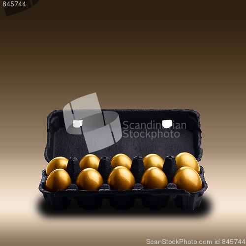 Image of Gold eggs in a black carton