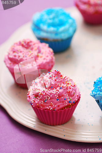 Image of freshly baked pink and blue cupcakes