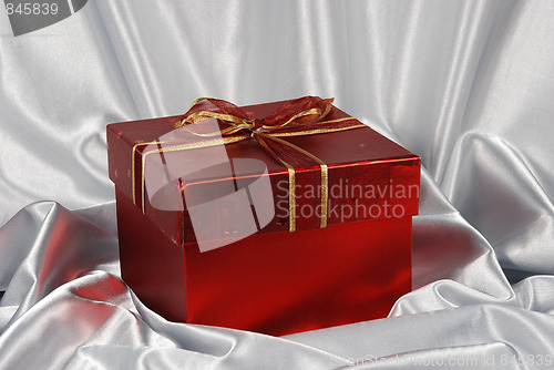 Image of red gift box on white satin background