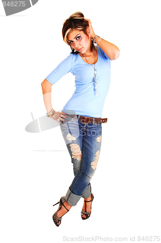 Image of Young woman standing in ripped of jeans.