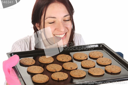 Image of beautiful housewife smelling of cakes 
