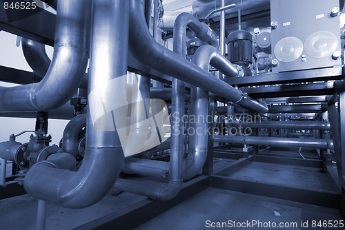 Image of Pipes, tubes, machinery and steam turbine at a power plant in bl