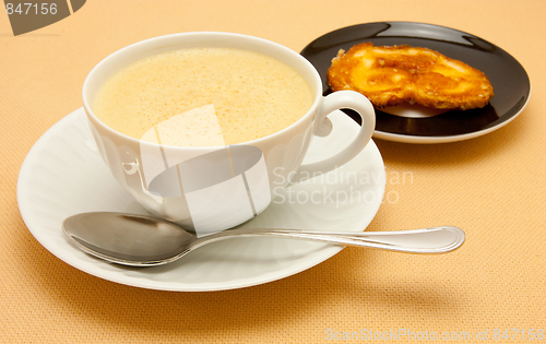 Image of Closeup of coffee with milk in white cup and a palmier pastry