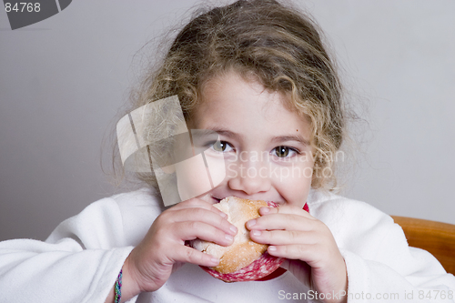 Image of cute little girl eating a sandwich