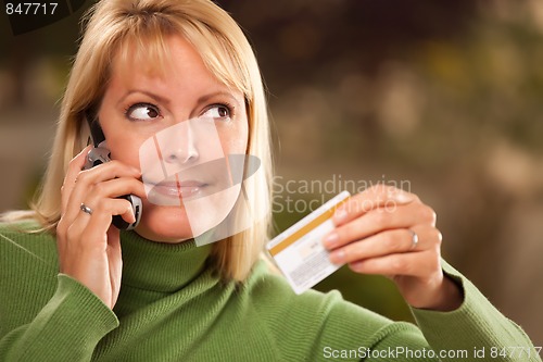 Image of Cheerful Woman Using Her Phone with Credit Card