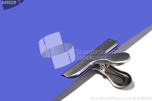 Image of Metallic paperclip on blue paper